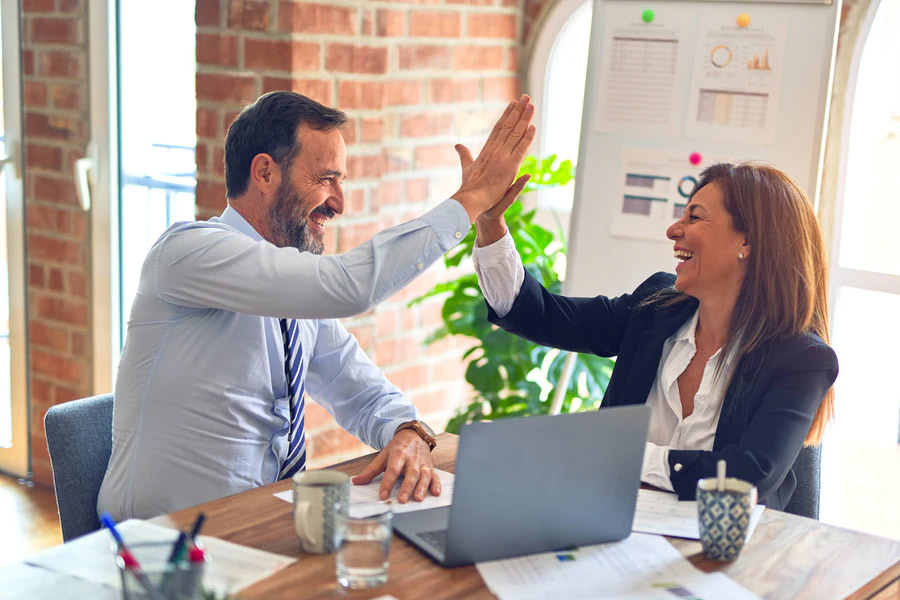 Business man and woman giving high fives | Commercial Insurance